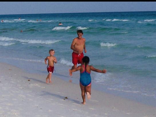 A man and children running on a beach