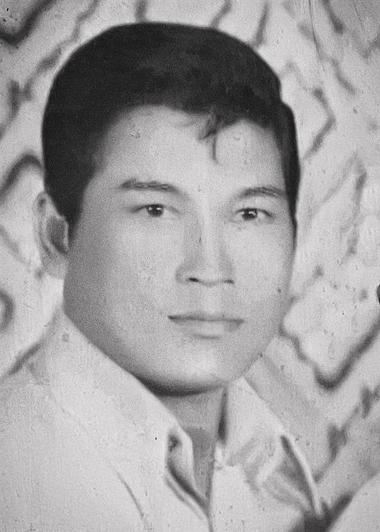 A young dark-haired man gazes at the viewer, embodying 1970s vintage style.