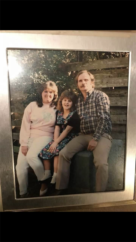 A family photo of a man and a woman sitting on a bench