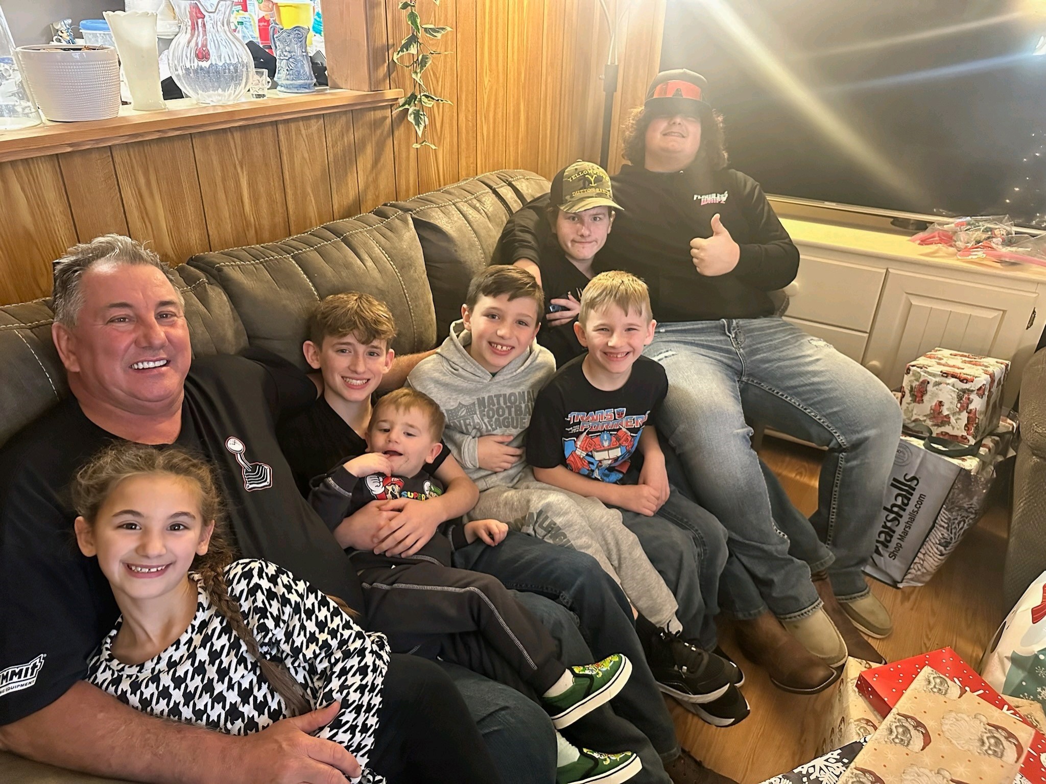 A joyful gathering of family members sitting together in a warm living room filled with laughter.