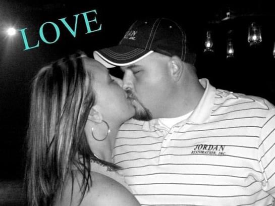A couple leans in for a kiss while surrounded by a warm atmosphere filled with affection.