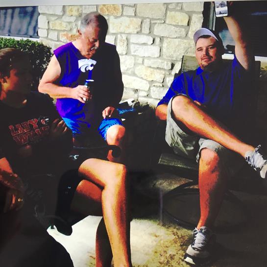 Three friends relax outdoors, chatting comfortably during a casual gathering.