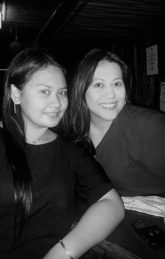 Two women are happily posing for a picture in a relaxed atmosphere, enjoying their time together.