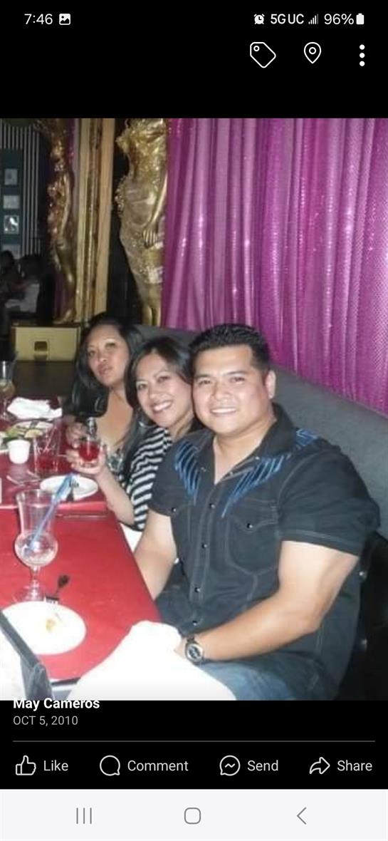 Three friends celebrate together at a colorful restaurant with drinks and smiles.