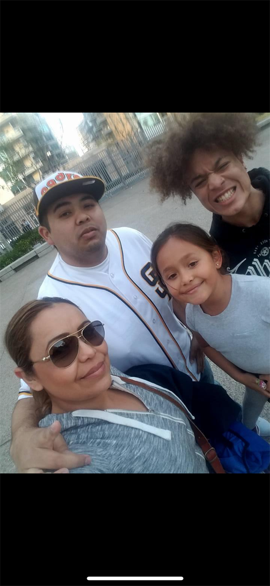 A family poses happily together in a park on a sunny day, making lasting memories.
