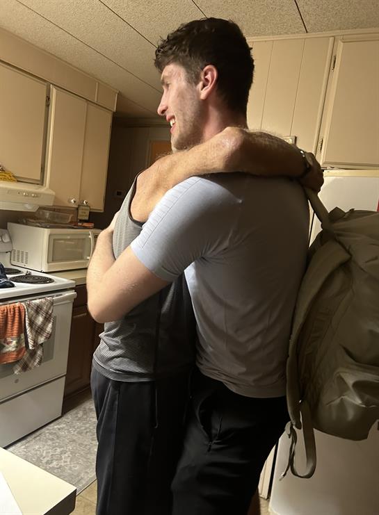 Friends enjoy a heartfelt moment together while surrounded by a homey kitchen atmosphere.