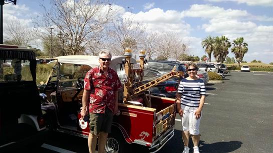 A couple of people standing next to a red truck