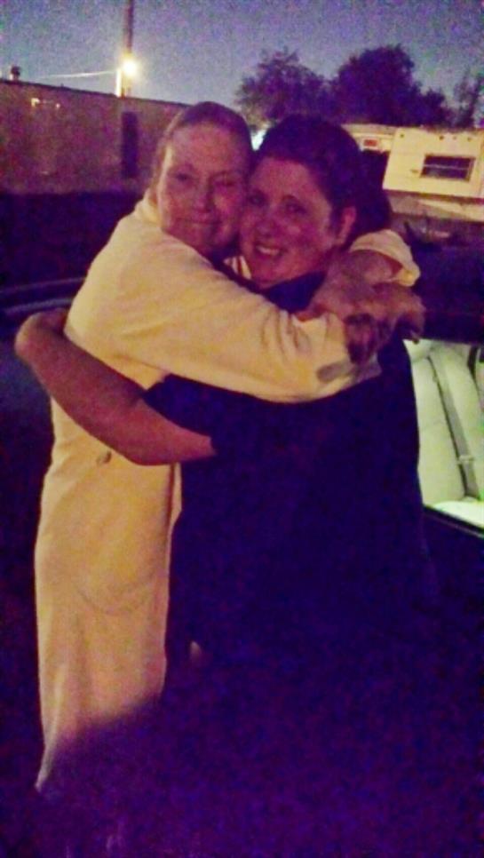 Friends share a warm and joyful hug in a casual atmosphere at night