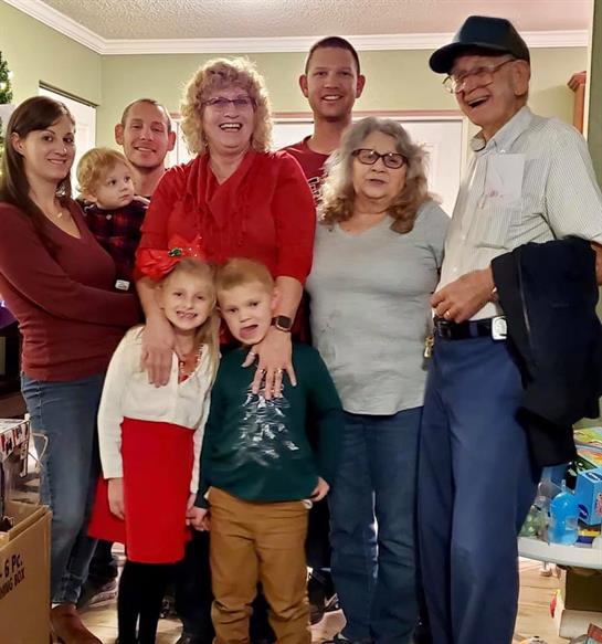 A family gathers together, sharing smiles and warmth during a festive holiday event.