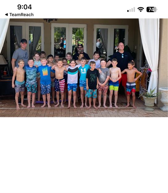 Many boys are gathered outside, enjoying a fun swim party with smiles and excitement.