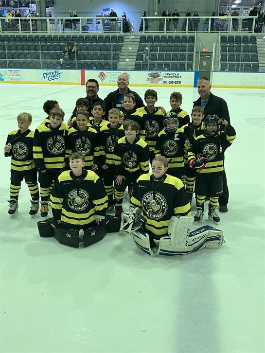 Young athletes celebrate their team spirit and achievements together on the ice.