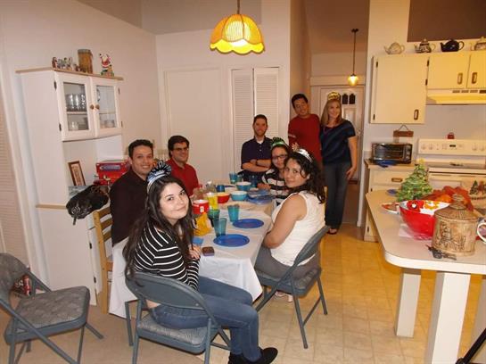Group of friends enjoying a lively dinner together in a warm, inviting kitchen space.