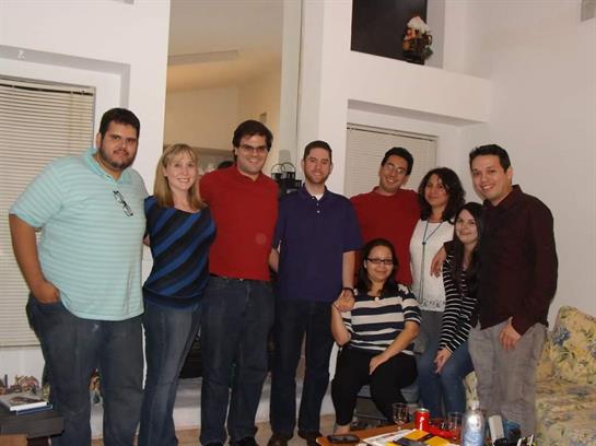 Friends pose together in a warm living room, enjoying each other's company and laughter.