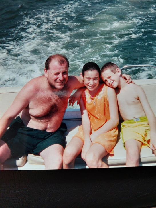 A man and two children on a boat