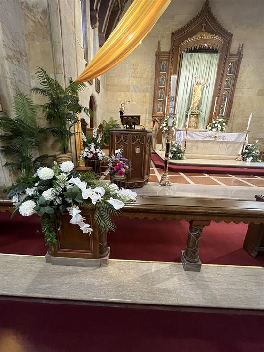 Beautiful floral decorations adorn the church altar, creating a serene atmosphere for worship.