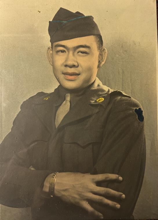 Soldier stands proudly in military uniform, arms crossed, conveying confidence and determination.