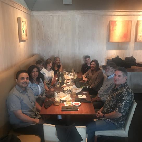 Friends gather around a table, sharing food and laughter at a restaurant during dinner time.