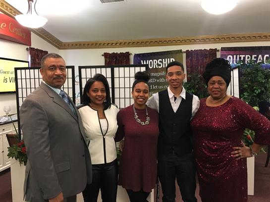 Group of five individuals pose together during a church event, showcasing unity and joy.