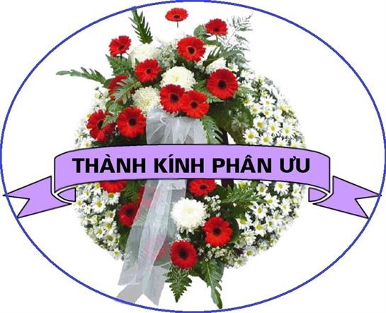 A floral wreath featuring red and white blooms is arranged for a memorial service.