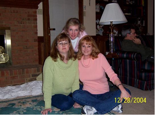 Group of friends poses together on the floor of a warm, inviting living room during winter.