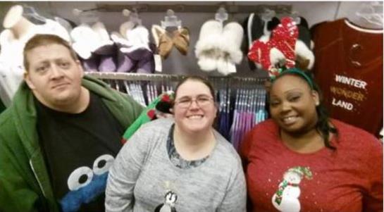 Three friends smile joyfully while shopping for holiday attire in a clothing store.