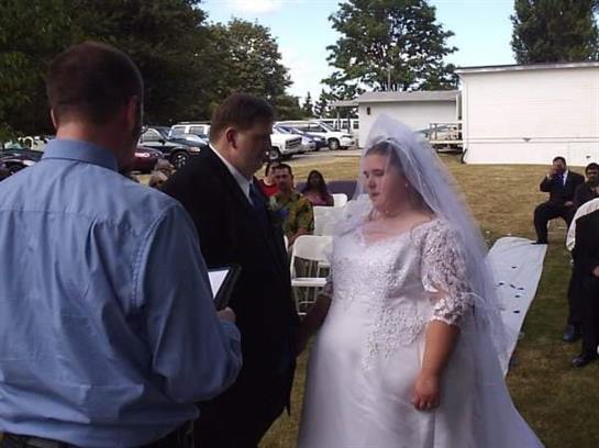 A couple exchanges vows during their outdoor wedding ceremony in a park.