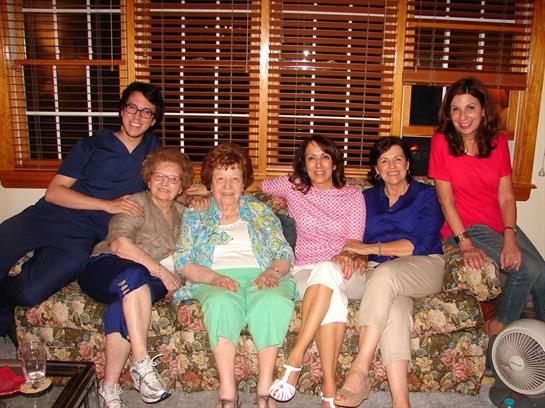 Family members sit together on a couch, sharing smiles and creating memories in their living room.