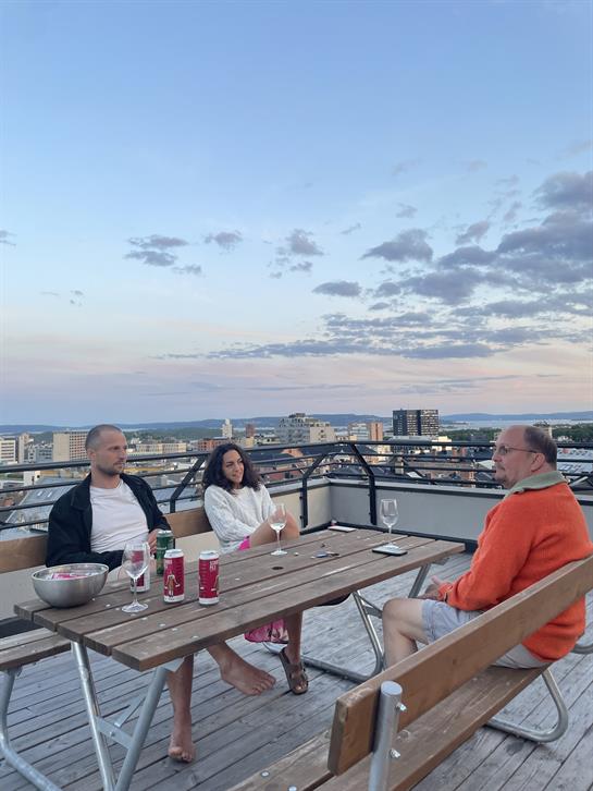 A group of people sitting at a table on a rooftop