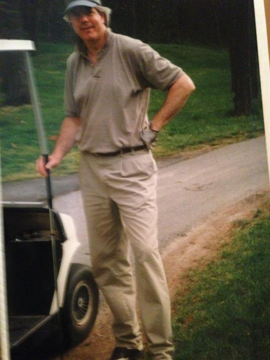 A man standing next to a golf cart