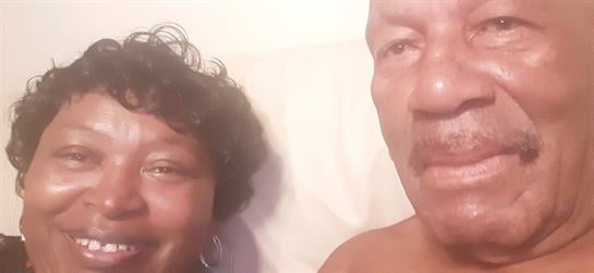 Happy couple shares a joyful moment in their living room, filled with smiles and love.