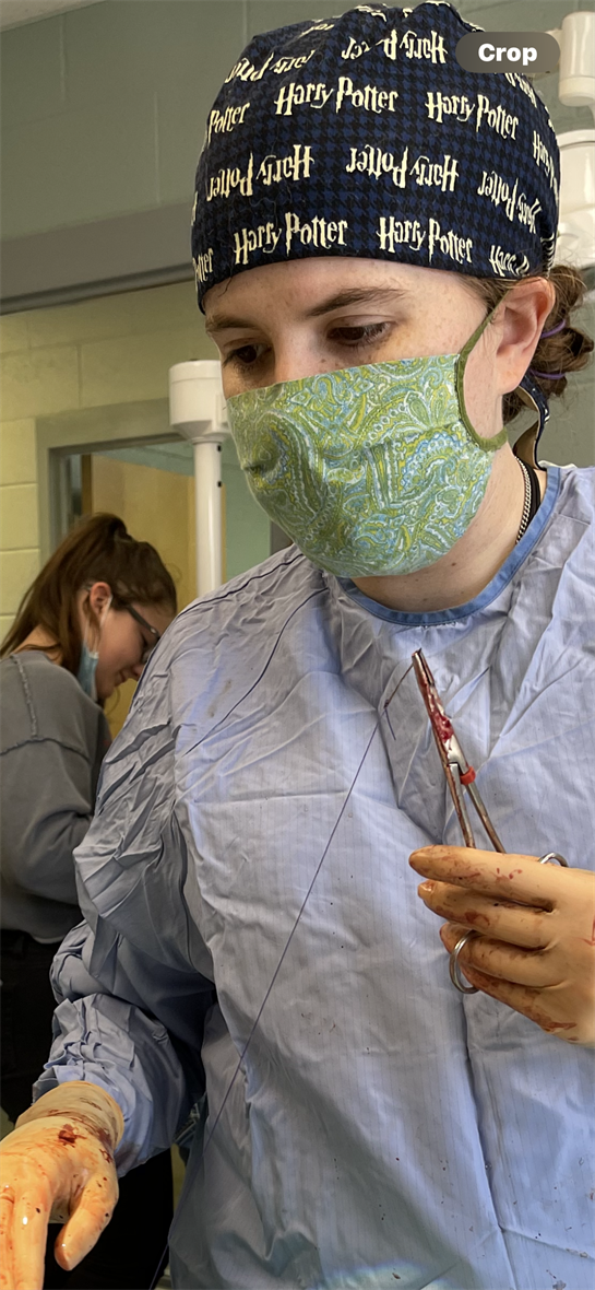 A woman wearing a mask and holding a pair of scissors