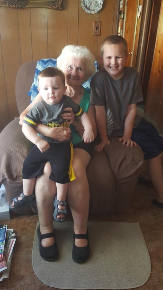 A woman and two boys sitting on a couch