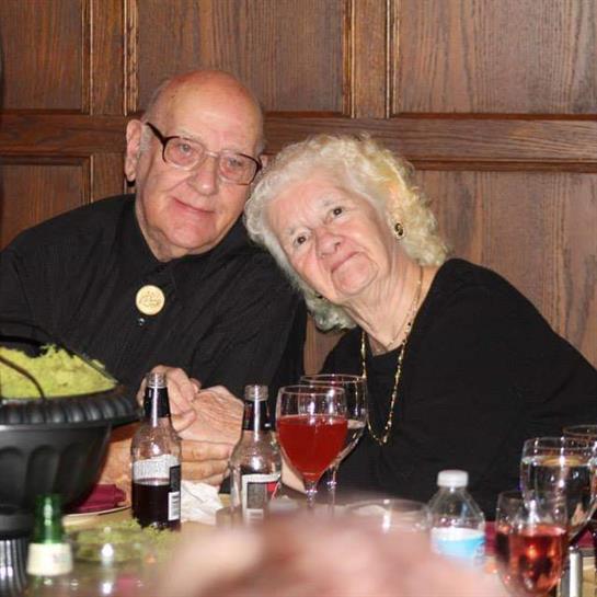 A man and woman sitting at a table with wine glasses