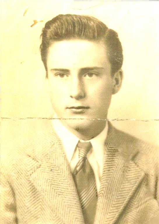 A young man poses confidently in a formal suit, likely from the 1940s.