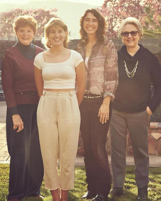 Group of women standing in a garden, enjoying each other's company and the sunny weather.
