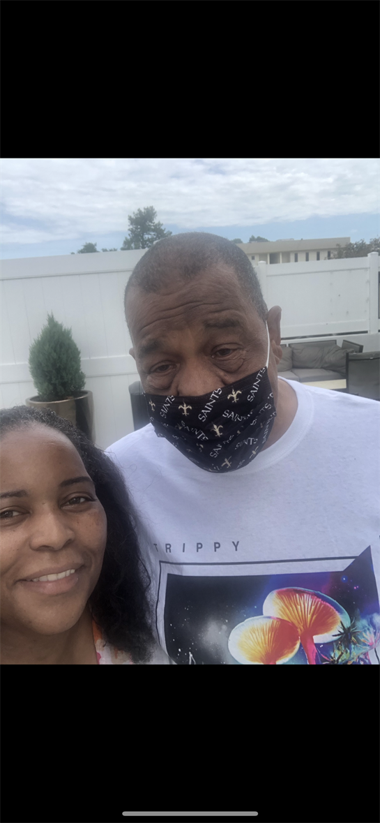 Two friends smile together outdoors, enjoying a relaxed moment while wearing masks.