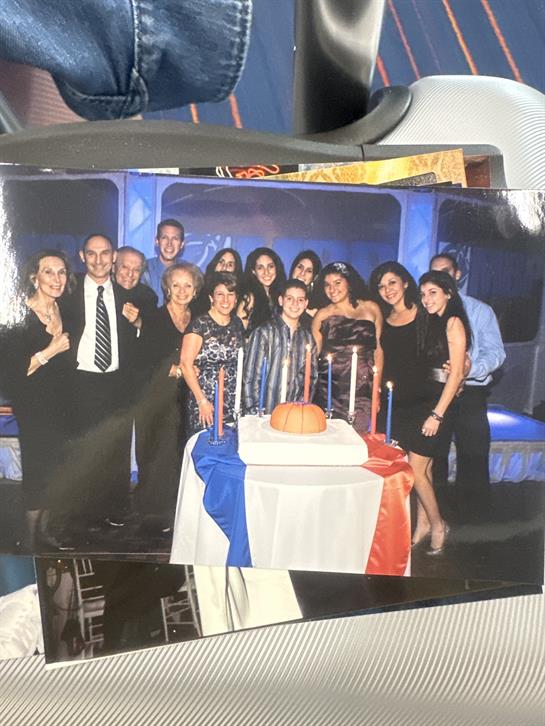 Family and friends enjoy a festive celebration around a beautifully decorated cake.