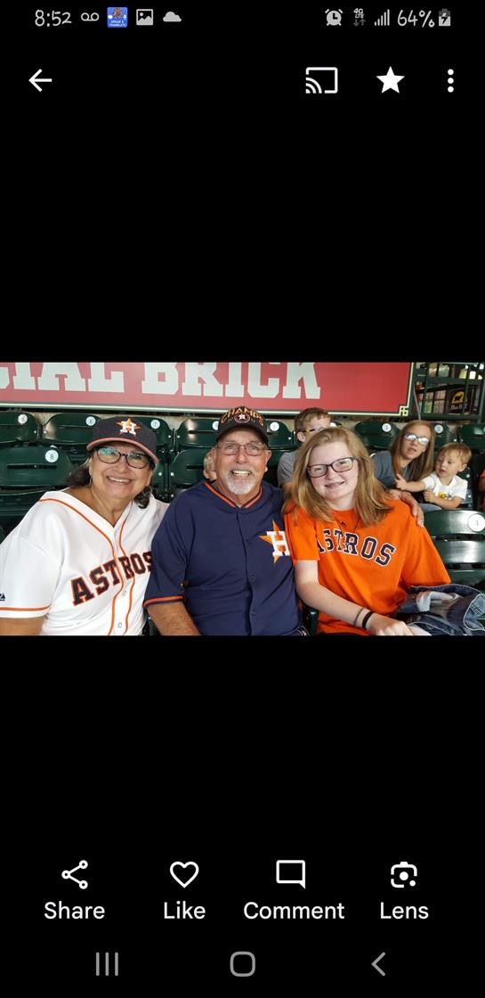 Friends and family gather at a baseball game, wearing jerseys and smiling cheerfully.