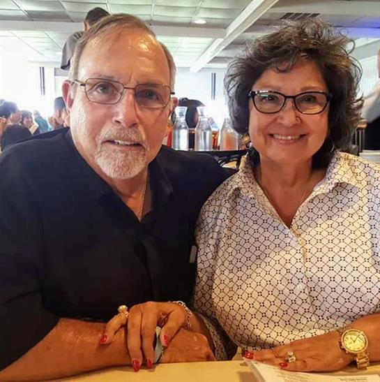 Two individuals smile while dining at a restaurant filled with natural light.
