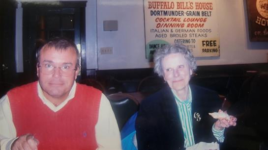 Two individuals share a meal in a warm dining environment, enjoying each other's company.