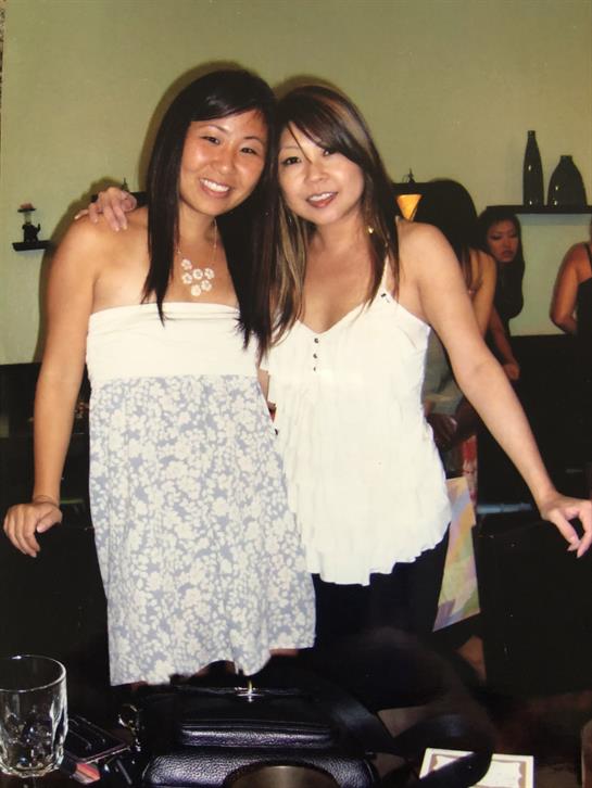 Friends smile together in a lively setting, enjoying each other’s company at a gathering.