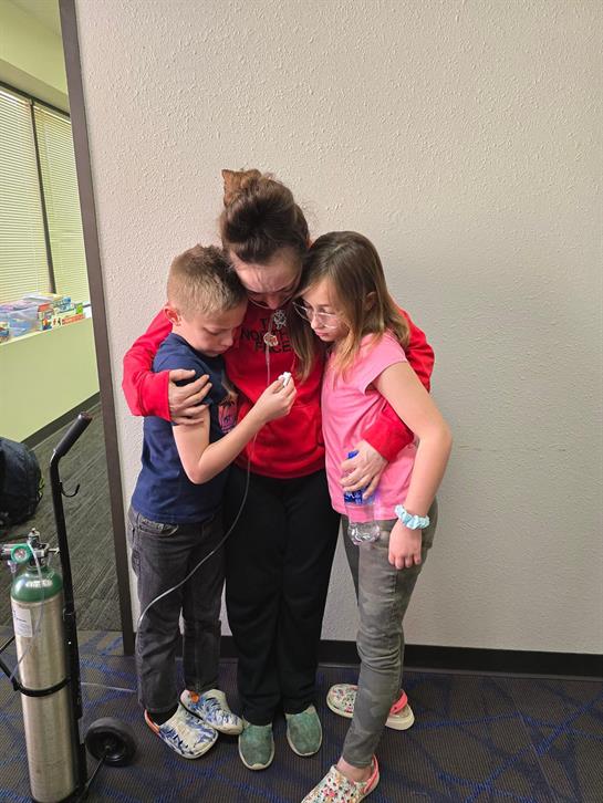 A woman and two children standing next to each other
