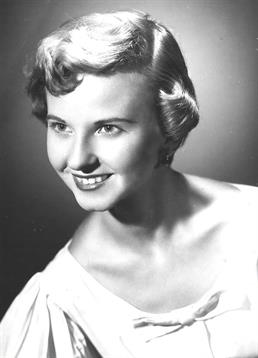 A young woman with stylish short hair displays a cheerful smile in a classic portrait.