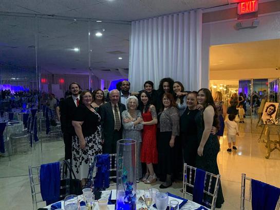 A joyful gathering of family and friends celebrating with smiles in a beautifully decorated venue.