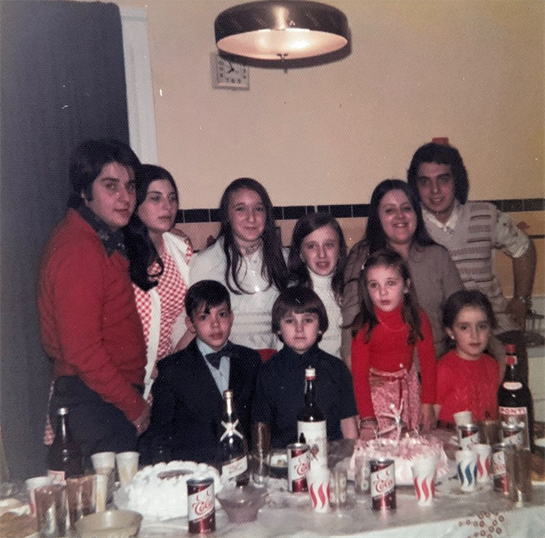 A large gathering showcases a joyful celebration with family, decorations, and festive drinks.
