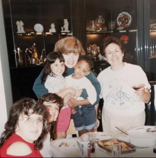 Family members and friends enjoy a joyful dinner together while sharing smiles and laughter.