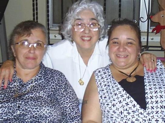 Three women share happiness and companionship during an intimate evening gathering.