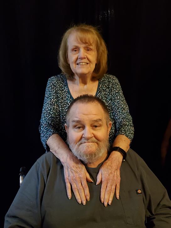 An older couple enjoys a tender moment in their home, radiating love and companionship.