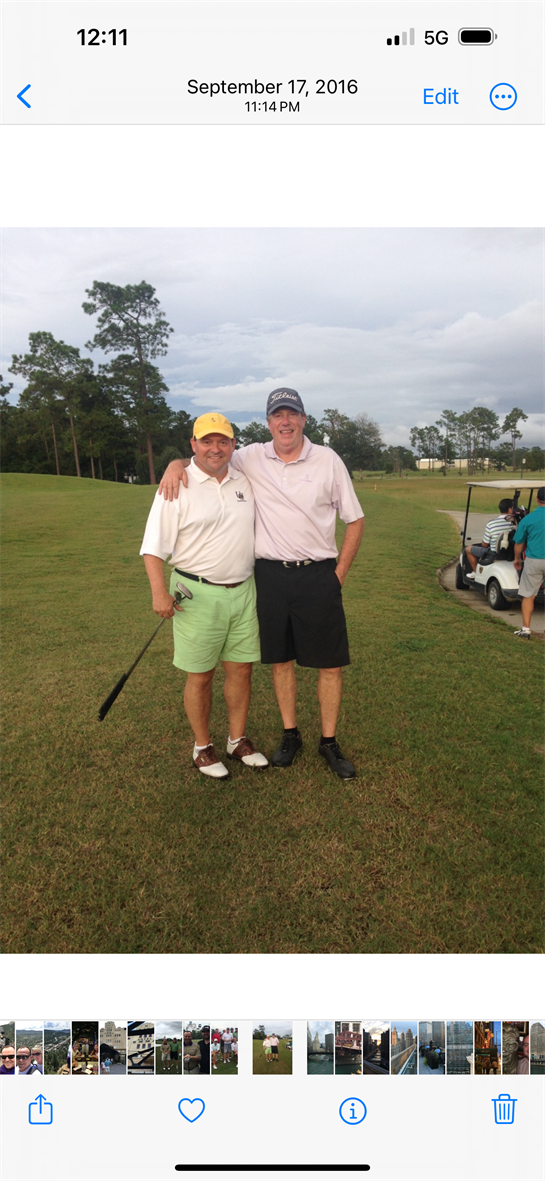 Friends enjoy a casual moment on the golf course, smiling and relaxed on a cloudy day.