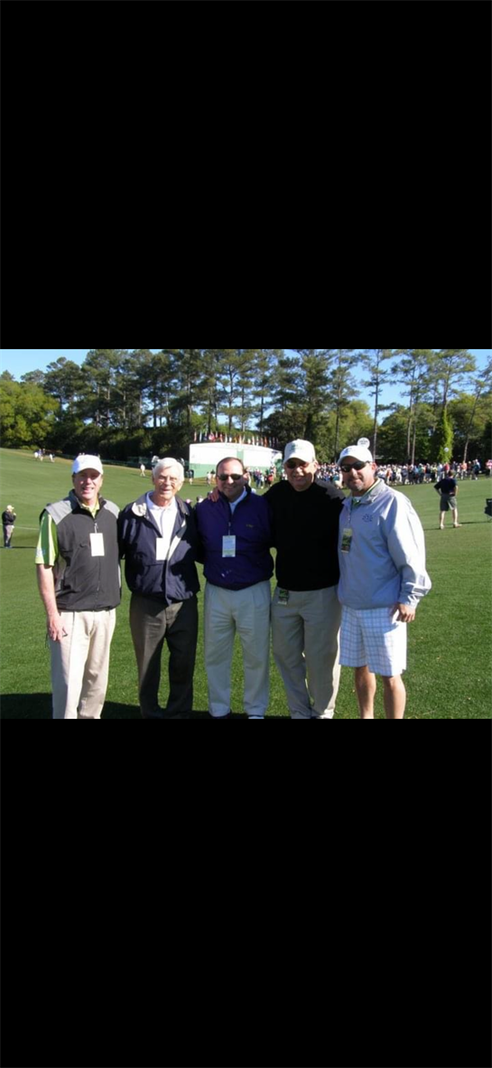 Friends gather for a casual moment at a golf course under clear blue skies.